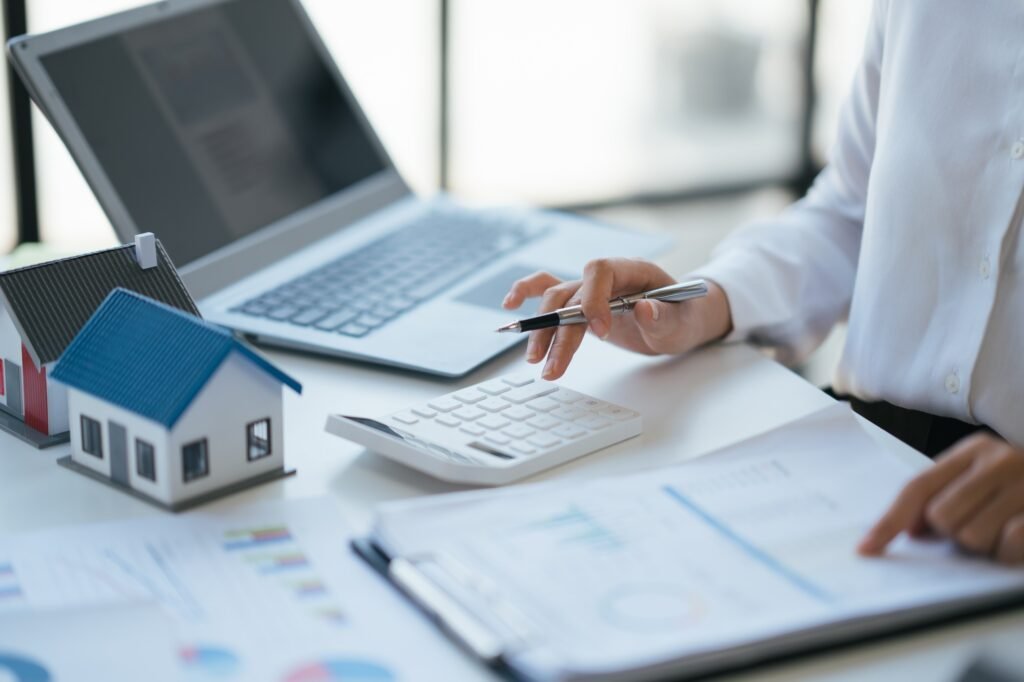 Close up view of young female real estate agency estimating the cost of the housing for the customer