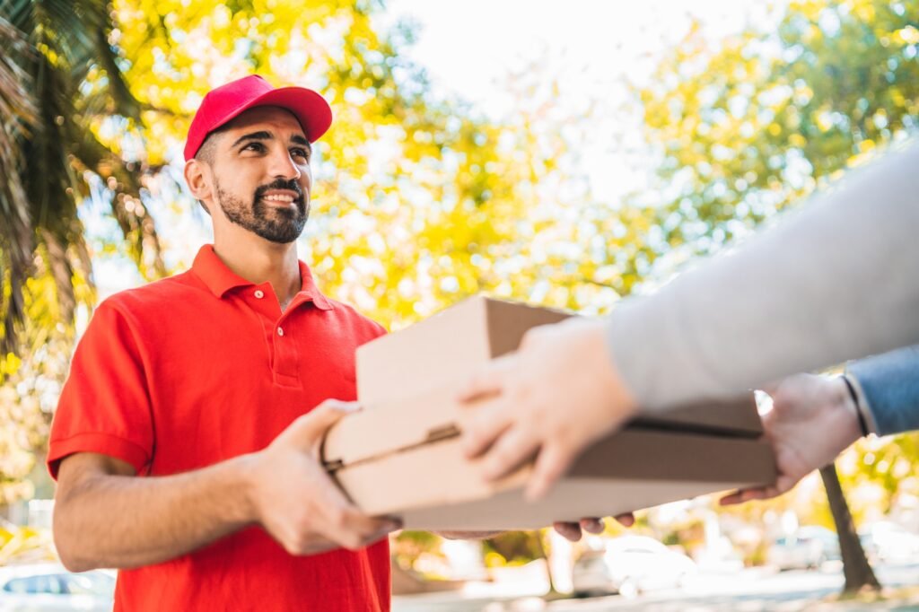 Delivery man carrying packages while making home delivery.